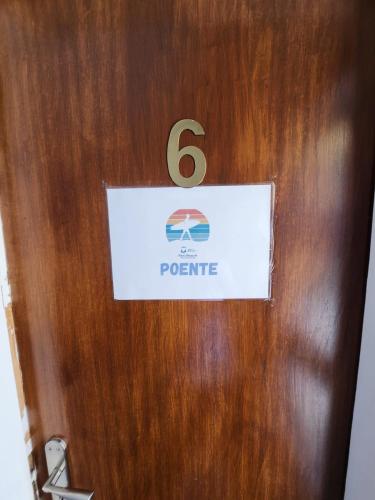 a wooden door with a sign on it with the number six at Blife Faro Beach Hostel & Rooms in Faro