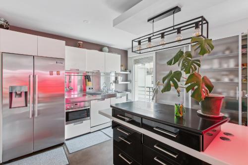 une cuisine avec des appareils en acier inoxydable et une plante en pot dans l'établissement Appartement proche de la Tour Eiffel, à Paris