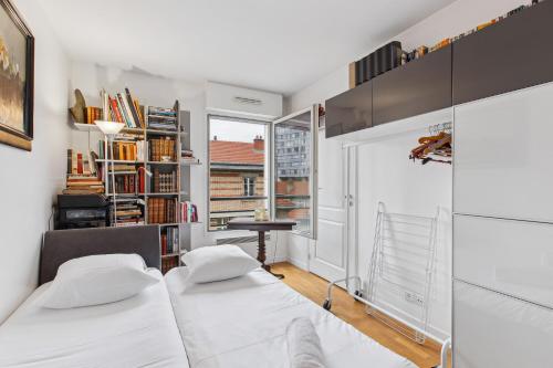 une chambre avec deux lits et une fenêtre dans l'établissement Appartement proche de la Tour Eiffel, à Paris