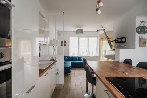 une cuisine avec des placards blancs et un canapé bleu dans l'établissement Maison des Clos Biais, à Dinard