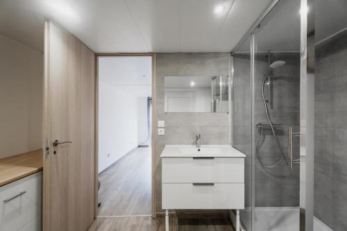 une salle de bain avec un lavabo blanc et une douche dans l'établissement Maison des Clos Biais, à Dinard