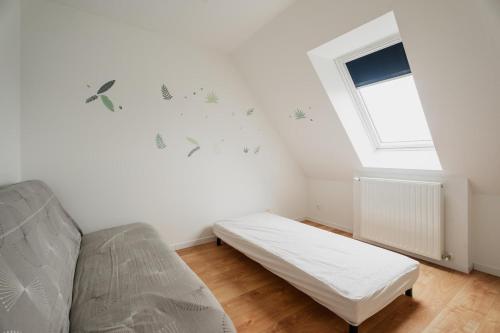 une chambre blanche avec un lit et une fenêtre dans l'établissement Maison des Clos Biais, à Dinard