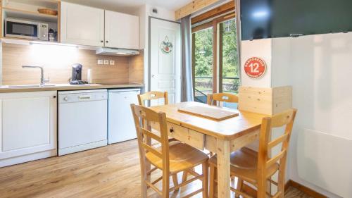 une petite cuisine avec une table et des chaises en bois dans l'établissement V DU BACHAT - MELEZES C23 - Studio 5 pers, à Chamrousse
