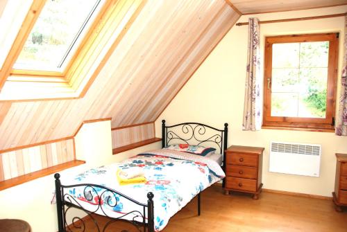 a bedroom with a bed and two windows at Domček pod Starým mestom in Banská Štiavnica