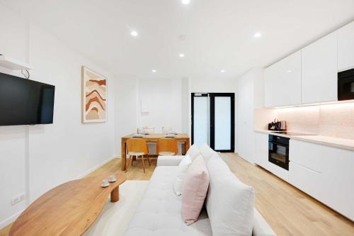 un salon blanc avec un canapé blanc et une table dans l'établissement Authentic apartment - 1BR-4P - Centre Pompidou, à Paris