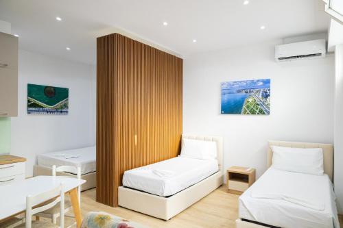 a small room with two beds and a table at Lungomare luxury apartament in Vlorë