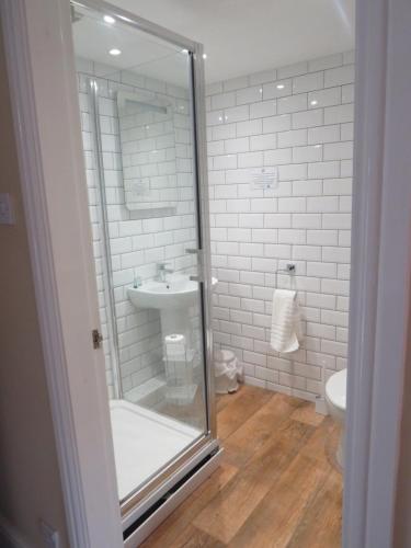 a bathroom with a glass shower and a sink at Ganton Greyhound Inn in Ganton