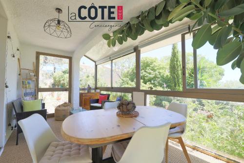 une salle à manger avec une table et des chaises blanches dans l'établissement Le verdi, à Sausset-les-Pins