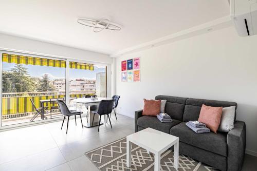 un salon avec un canapé et une table dans l'établissement Elegance and serenity with terrace, view & A-C, à Cannes