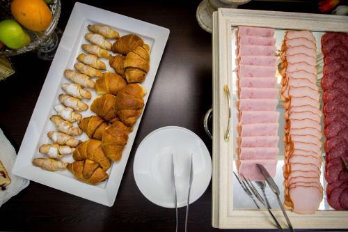 einen Tisch mit verschiedenen Fleischsorten und anderen Lebensmitteln in der Unterkunft Best Western Central Hotel in Arad