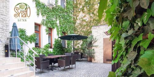 a patio with a table and chairs and an umbrella at Shato Luxe in Odesa