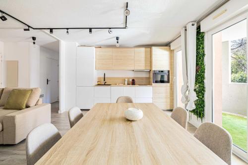 une cuisine et une salle à manger avec une table et des chaises en bois dans l'établissement Comfort and serenity with A-C, Parking and Balcony, à Cannes