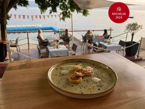 a plate of food on a table with a view of the ocean at Boutique Hotel Marco Polo in Gradac