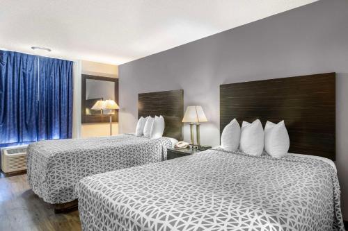 a hotel room with two beds and a window at Suburban Studios International Drive in Orlando