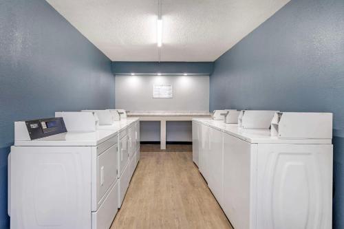 a room with white washing machines and a table at Suburban Studios International Drive in Orlando