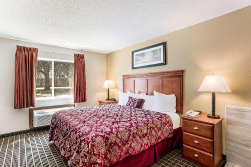a hotel room with a bed and a window at Rodeway Inn Cedar Rapids Westdale in Cedar Rapids
