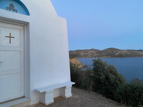 a white door with a cross on the side of a building at Villa Infinity View Athens Riviera in Anavissos