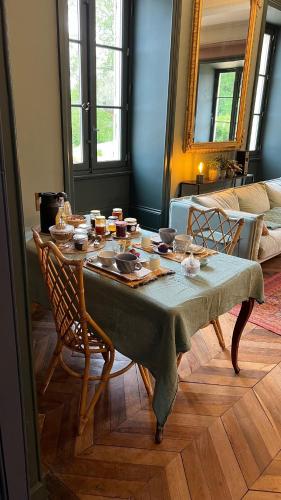 een eettafel met een groene tafelkleed en stoelen bij Château de Lemps in Lemps
