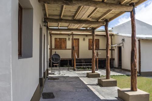 an outdoor patio with a wooden pergola at Posada La Sofia in Tafí del Valle