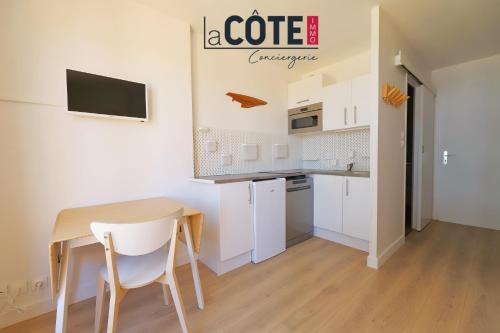 une petite cuisine blanche avec une table et des chaises dans l'établissement la daurade, à Carry-le-Rouet