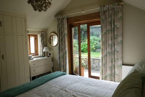 a bedroom with a bed and a large window at Peak District Luxury cottage, sleeps 8 plus pets in Tideswell