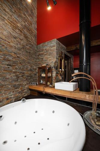 a bathroom with a white sink and a brick wall at Terra Lodge in Hoz de Jaca