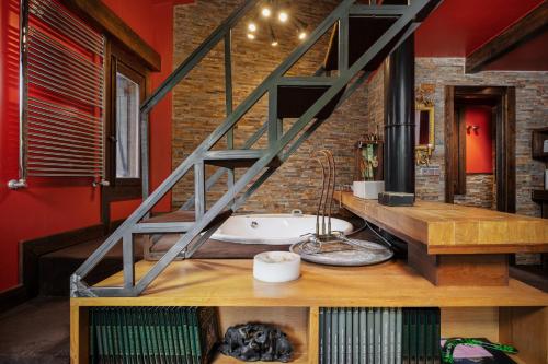 a bathroom with a staircase above a bath tub at Terra Lodge in Hoz de Jaca