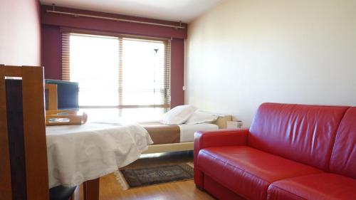 Cette chambre dispose d'un canapé, d'un lit et d'une fenêtre. dans l'établissement Rue de Longchamp - Paris 16, à Paris