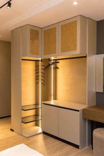 a kitchen with white cabinets and wood floors at Diora'S Hotel and Apartments in Vlorë