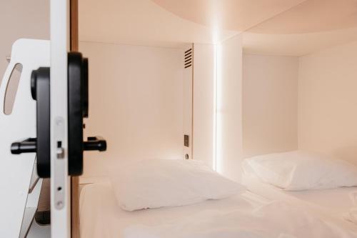 a bedroom with a mirror next to a bed at Hostel by Hyve Basel in Basel