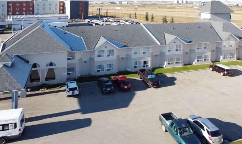 a large building with cars parked in a parking lot at Quality Inn & Suites Edmonton International Airport in Leduc