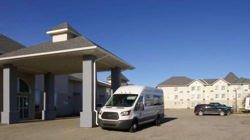 a white van parked in a parking lot next to a building at Quality Inn & Suites Edmonton International Airport in Leduc