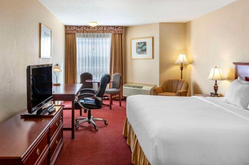 a hotel room with a bed and a desk at Quality Inn & Suites Edmonton International Airport in Leduc