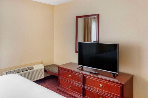 a hotel room with a flat screen tv on a dresser at Quality Inn & Suites Edmonton International Airport in Leduc