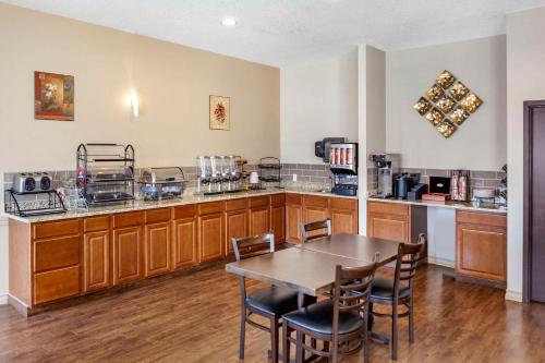 a kitchen with a table and chairs and a counter at Quality Inn & Suites Edmonton International Airport in Leduc