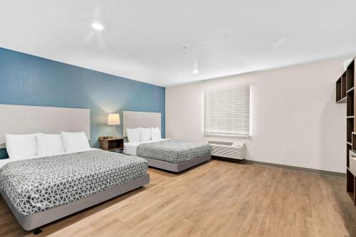 two beds in a room with blue walls at WoodSpring Suites Indio - Coachella Valley in Indio
