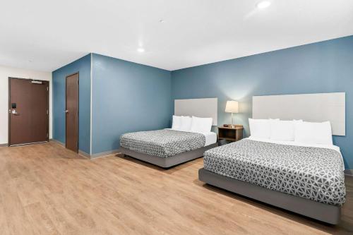 two beds in a room with blue walls at WoodSpring Suites Indio - Coachella Valley in Indio
