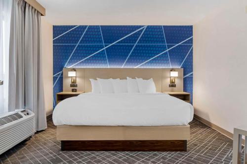 a bedroom with a large bed and a blue wall at Comfort Inn & Suites Rapid City near Mt Rushmore in Rapid City