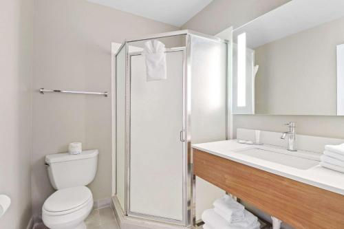 a bathroom with a shower and a toilet and a sink at Clarion Pointe Ridgecrest near China Lake Naval Station in Ridgecrest
