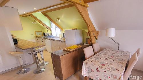 a kitchen with a table and a kitchen with a refrigerator at Gîtes Ange et Bacchus in Villecresnes