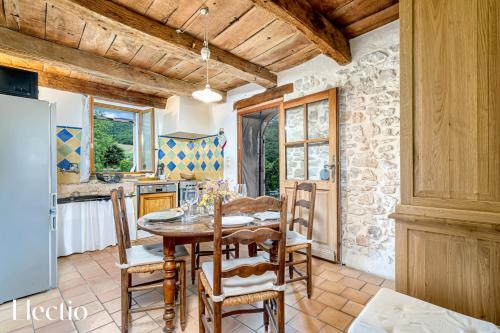 une cuisine et une salle à manger avec une table et des chaises dans l'établissement Mas La Miellerie - Charme Authentique et Nature, à Simiane-la-Rotonde
