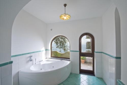 un bagno con ampia vasca e finestra di Villa Tranquillita a Praiano
