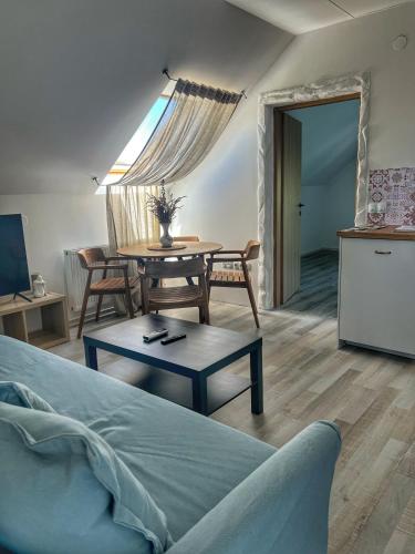 a living room with a bed and a table and a kitchen at Apartman Cherry Plitvice Lakes in Irinovac