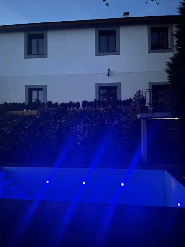a white house with blue lights in front of it at El Lagar de Luarca in Luarca