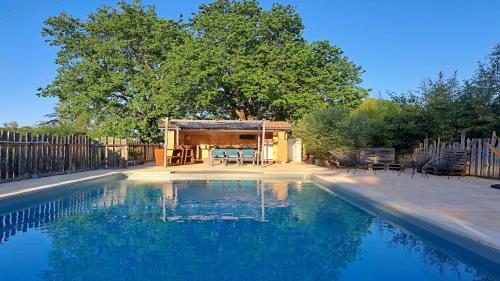 - une piscine avec un kiosque et une maison dans l'établissement L Escapade Nature et Gourmande Gîtes, Chambres d'Hôtes, piscine, Spa Toulouse Colomiers Gers, à Pujaudran
