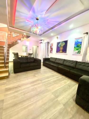 a living room with black couches and a purple ceiling at Supreme 3-BED-Duplex With 24HRS PWR & FREE Wi-Fi in Lagos