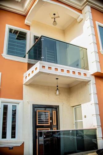 a large house with a balcony and a door at Supreme 3-BED-Duplex With 24HRS PWR & FREE Wi-Fi in Lagos