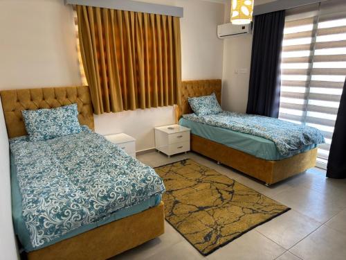 a bedroom with two beds and a window at Royal Sun in Iskele