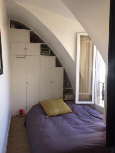 Ce lit se trouve dans une chambre mansardée. dans l'établissement Location studio Paris 11, à Paris