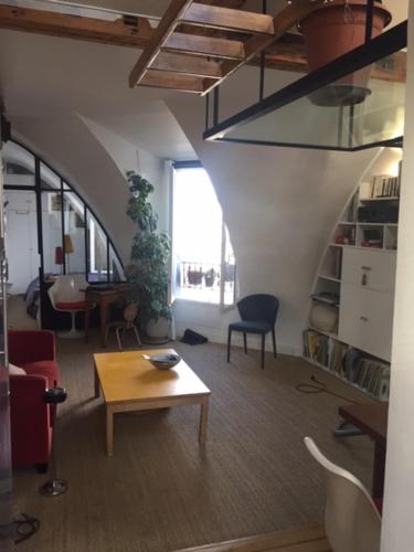 - un salon avec une table, un canapé et une chaise dans l'établissement Location studio Paris 11, à Paris